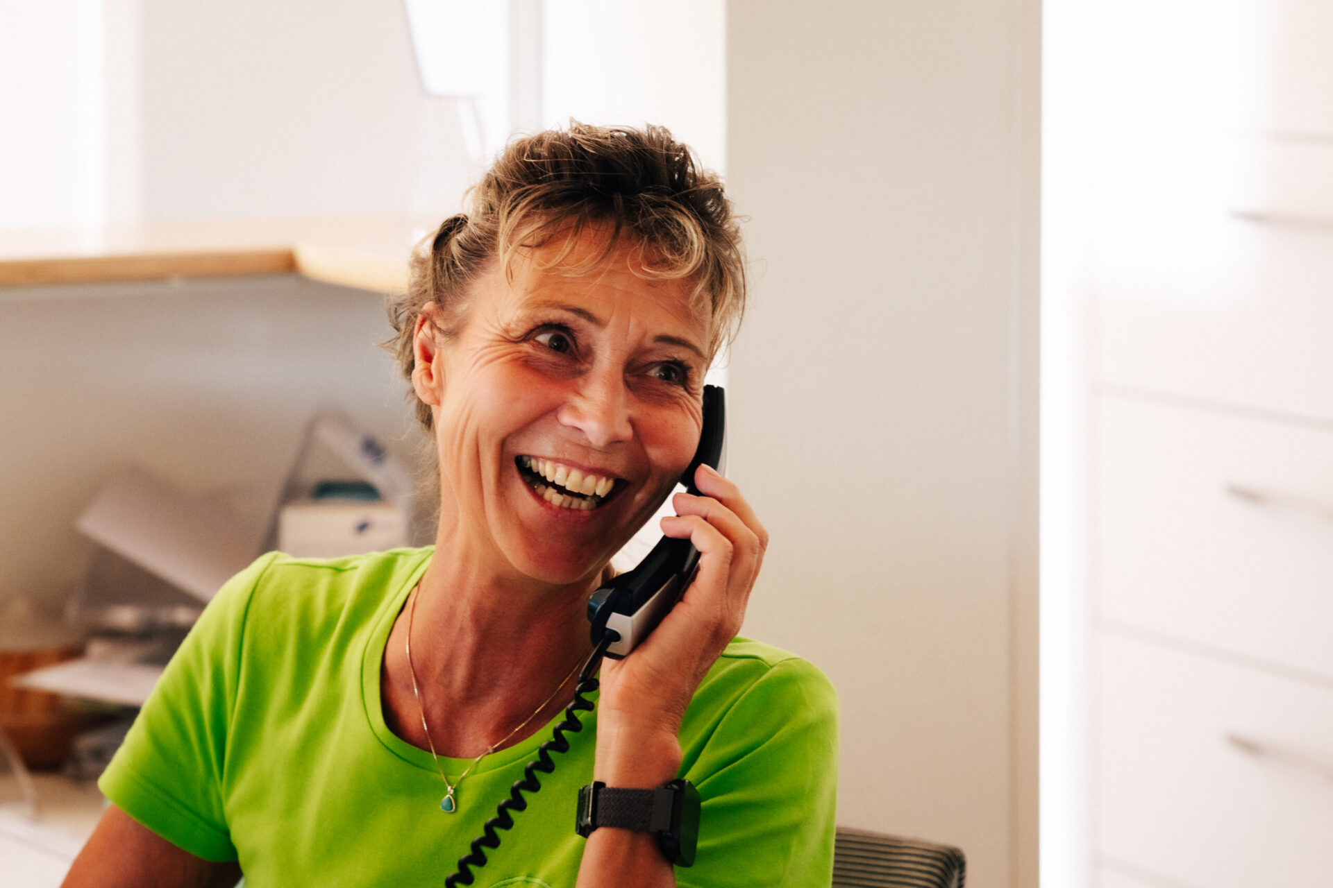 Praxisfotos Dr. E. Seidel - Juli 2026-107 Eine Frau telefoniert im Empfangsbereich einer Arztpraxis